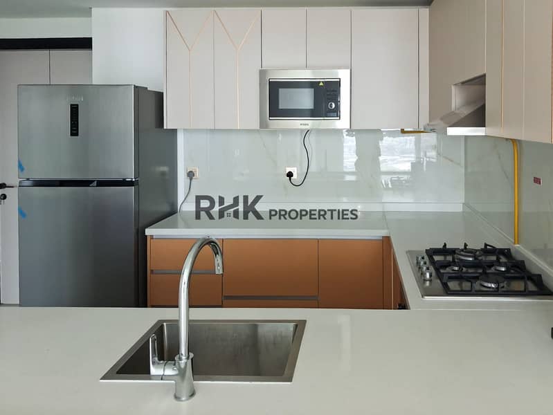 8 Modern fitted kitchen with stainless steel sink, gas hob and fridge in Dubai apartment