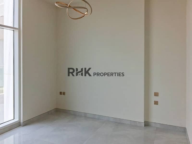 5 Spacious empty bedroom with designer pendant light and floor-to-ceiling windows in Dubai high-rise