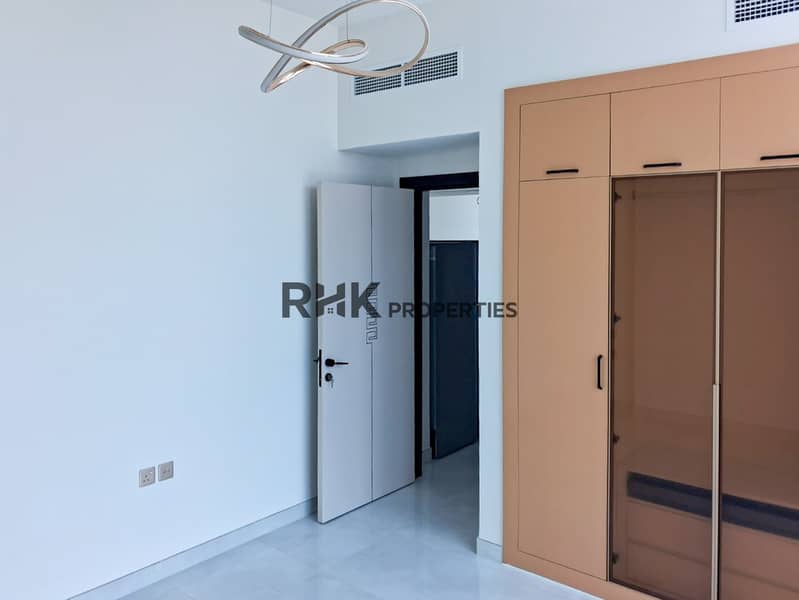7 Contemporary bedroom with decorative white door and copper-tone built-in wardrobe in Dubai apartment