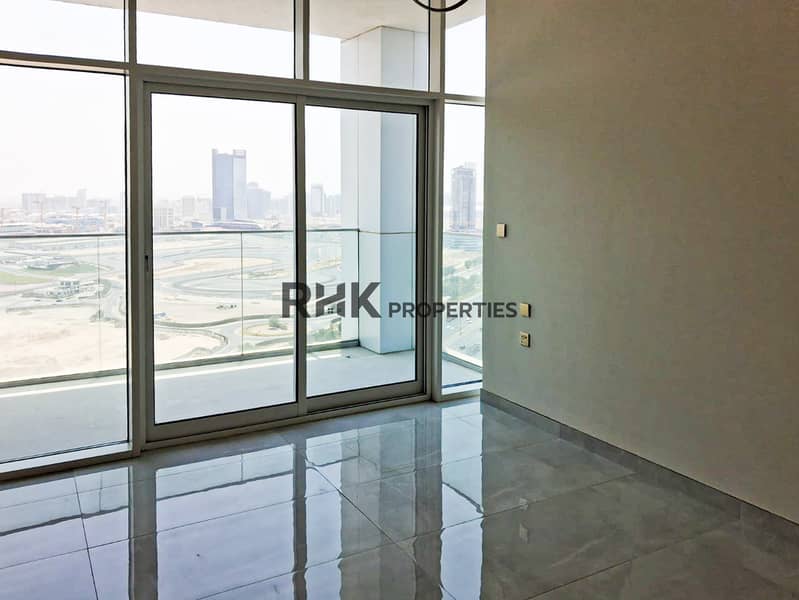 12 Light-filled room with sliding glass balcony door and Dubai racing circuit view