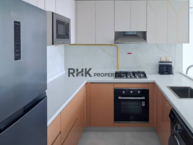 13 Fully equipped kitchen with built-in oven, gas hob, range hood and copper cabinetry in Dubai apartment