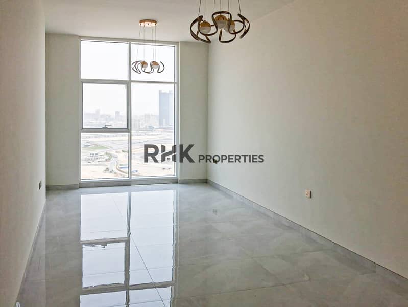 3 Bright open-plan reception room with floor-to-ceiling windows and Dubai Autodrome view