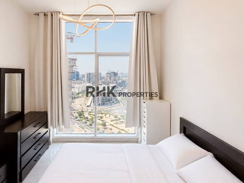 2 Modern fully equipped kitchen with gold cabinetry, gas hob, oven, and stainless steel refrigerator in Dubai apartment