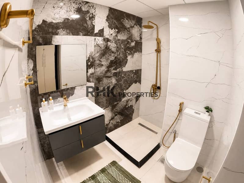 8 Spacious master bedroom with king-size bed, mirrored wardrobe, and marble-effect flooring in Dubai