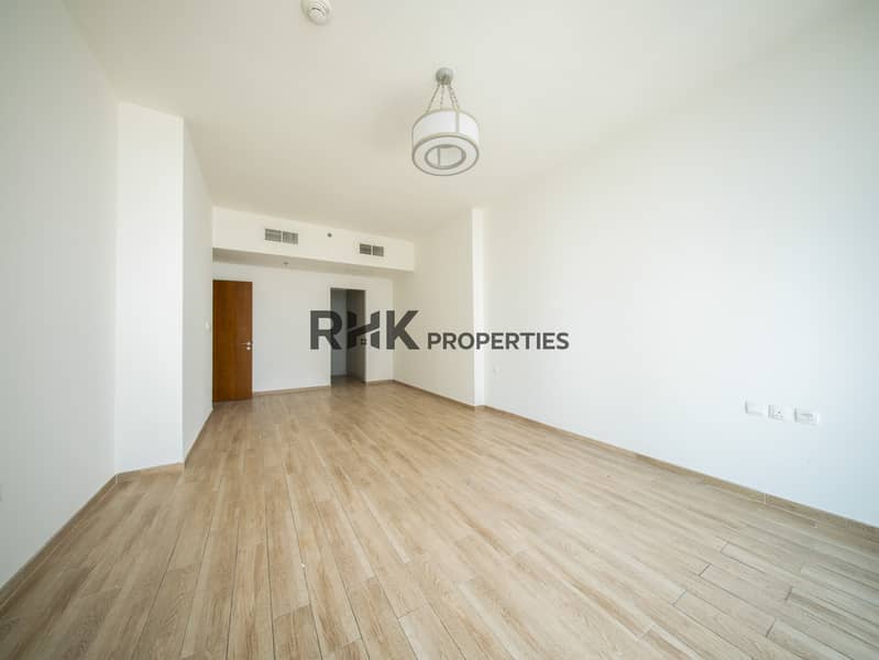 2 Bright secondary bedroom with wood-effect flooring and en-suite access in Dubai residential apartment
