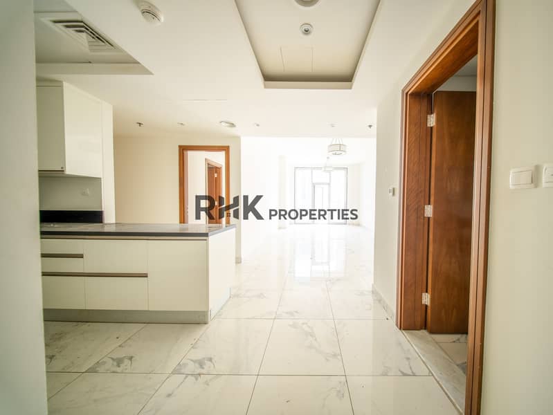 5 Open-plan kitchen and living area with marble flooring and white cabinetry in Dubai apartment