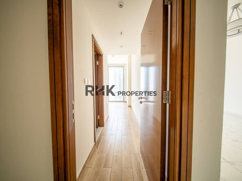 9 Private bedroom corridor with wooden doors and wood-effect tile flooring in Dubai apartment