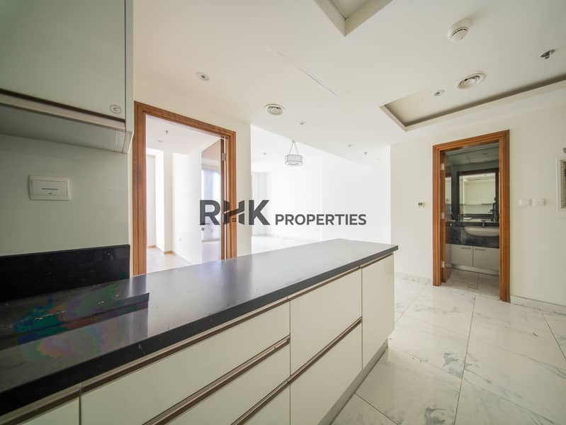 13 Kitchen breakfast bar with black granite top opening to bright living area and guest bathroom in Dubai flat