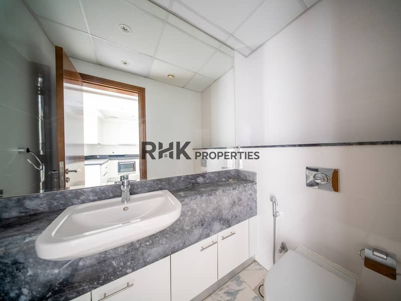 14 Guest bathroom with grey marble vanity, white basin and chrome fixtures in Dubai apartment