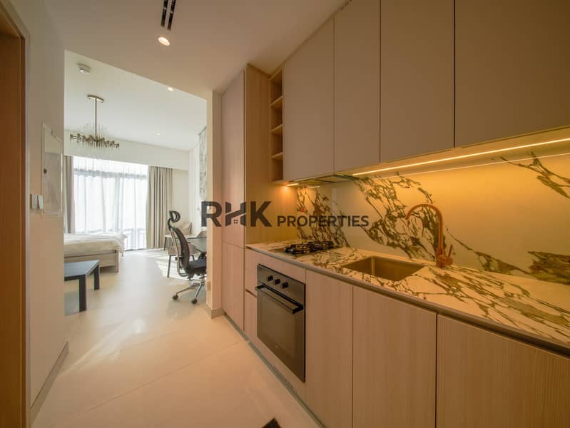 7 Galley kitchen leading to entrance and en-suite bathroom in furnished Dubai studio apartment