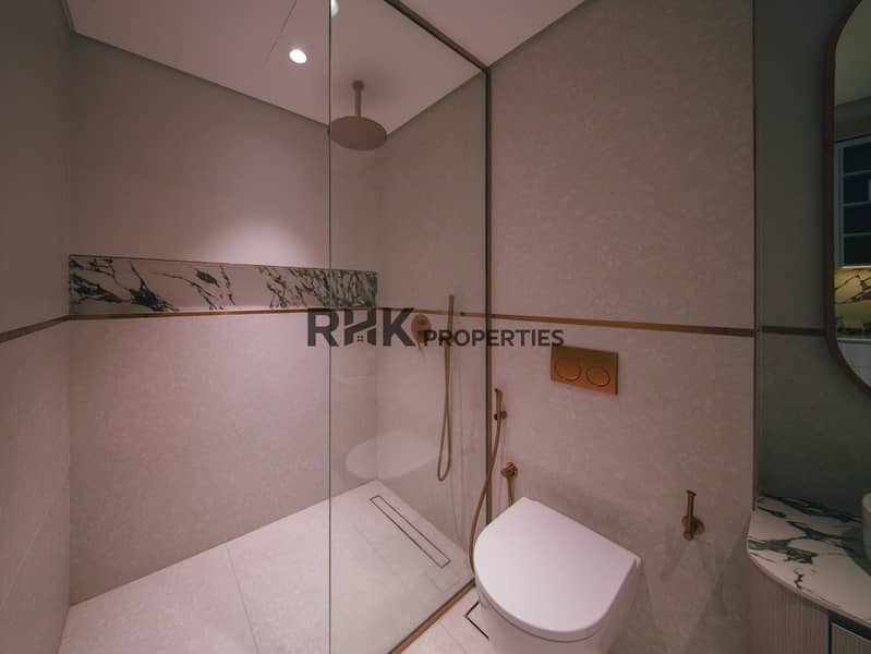 11 Walk-in glass shower with rain head and rose gold fittings in luxury Dubai studio apartment
