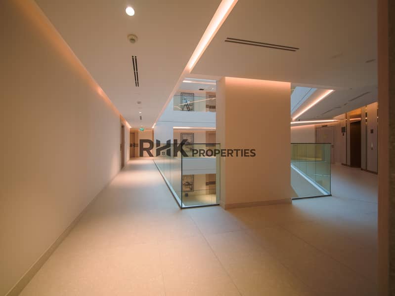 13 Spacious apartment corridor with glass atrium and elevator lobby in Dubai residential building