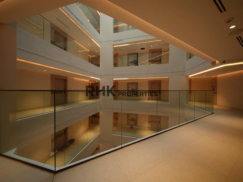 14 Warmly lit internal atrium and apartment corridors in modern Dubai residential tower Primary keyword: Dubai residential tower atrium