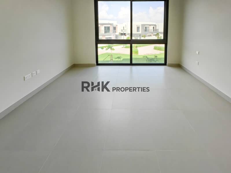 6 Bright bedroom with floor-to-ceiling windows overlooking landscaped community park in Dubai