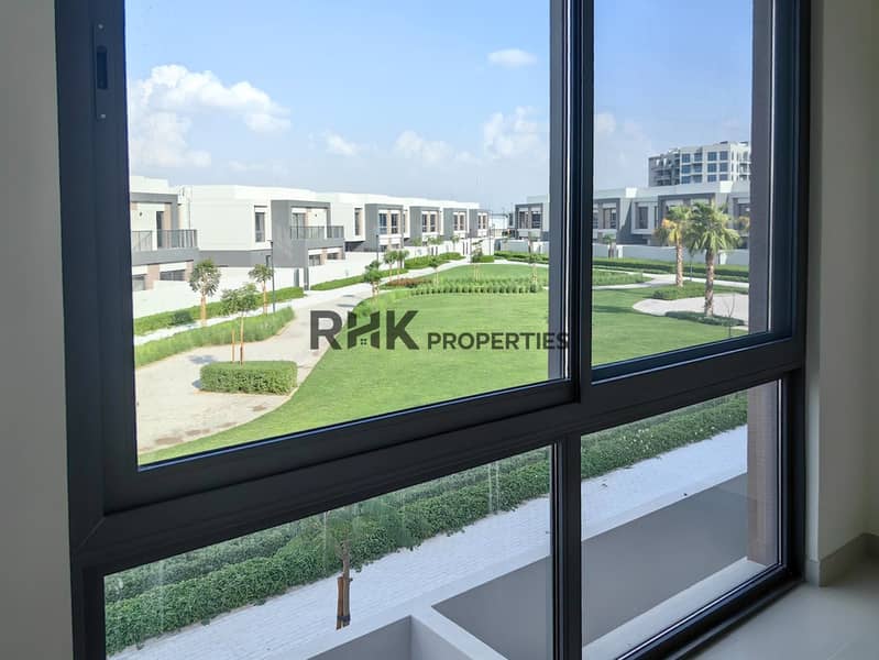 7 Window view of landscaped green park with palm trees in gated townhouse community Dubai
