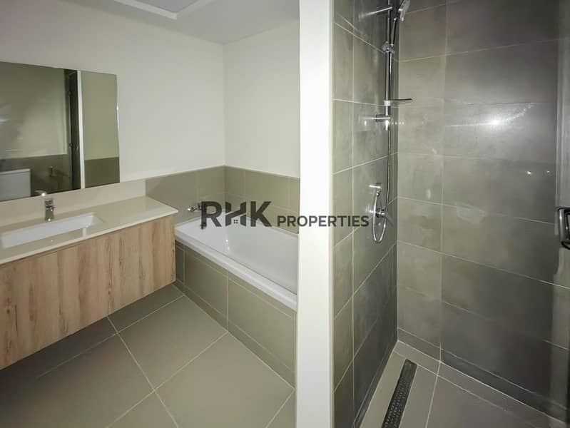 11 Master bathroom with bathtub, separate shower, wood vanity and large mirror in Dubai townhouse