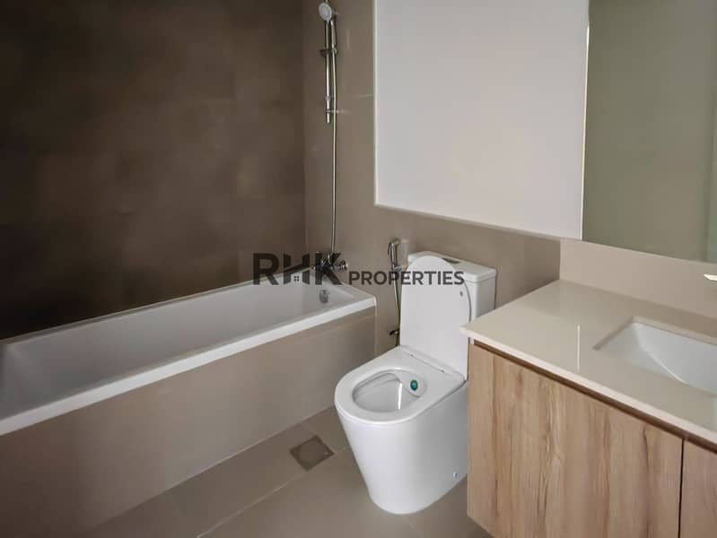 13 En-suite bathroom with soaking tub, toilet and wood vanity unit in Dubai residential townhouse