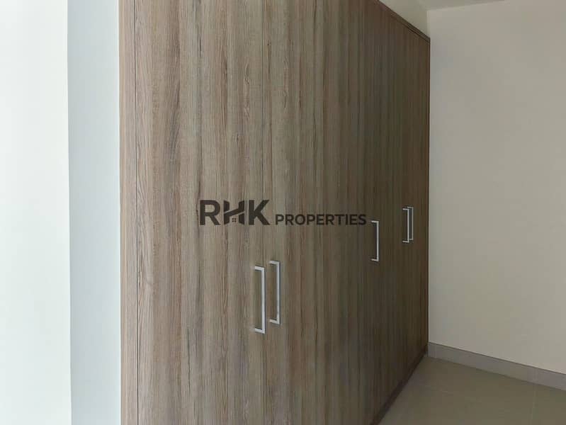 21 Large built-in floor-to-ceiling wood wardrobe with metal handles in Dubai townhouse bedroom