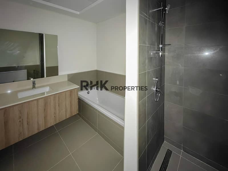 22 Master bathroom with bathtub, separate shower enclosure, floating wood vanity and large mirror in Dubai townhouse