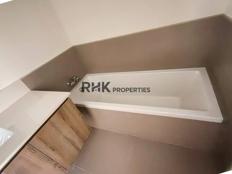 23 Master bathroom with bathtub, separate shower enclosure, floating wood vanity and large mirror in Dubai townhouse