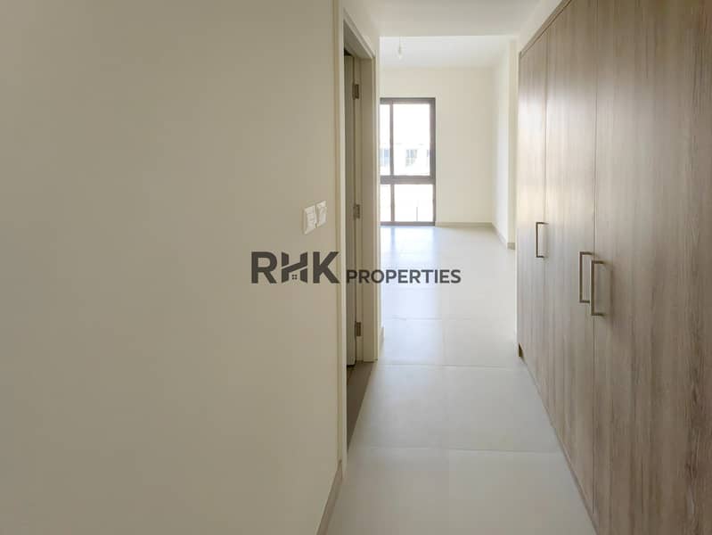 24 Bright bedroom hallway with built-in wood wardrobe and balcony window view in Dubai townhouse