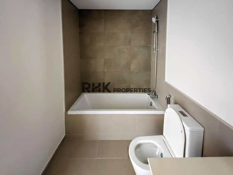 26 En-suite bathroom with bathtub, toilet, shower and floating wood vanity in Dubai gated community townhouse