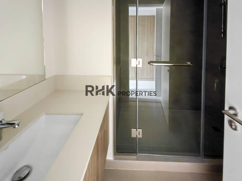 28 Master en-suite bathroom with glass shower enclosure, quartz vanity and dark tile walls in Dubai townhouse