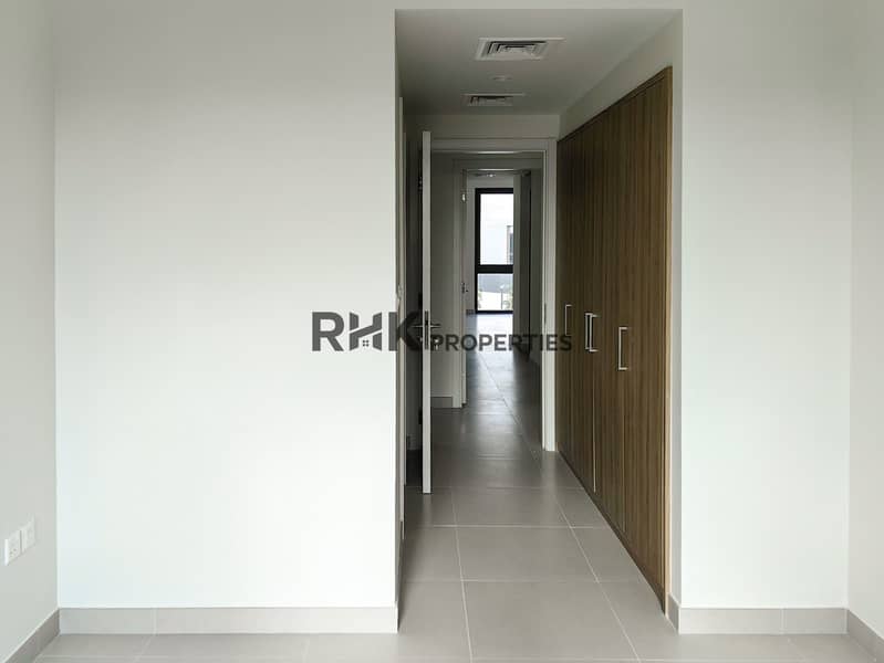 29 Bedroom doorway opening to tiled hallway with built-in wood wardrobe in modern Dubai townhouse