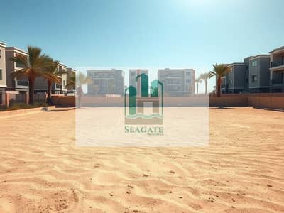 Mixed Use Land te Koop in Al Alia, Ajman - A_vast_and_expansive_residential_plot_set_in_a_suburban_neighborhood_emphasizing_the_idea_of_a_very_large_piece_of_undeveloped_land. _The_foreground_includes_a_wide_sandy_area_bordered_by_a_low_wall_with_palm_trees_an. jpeg