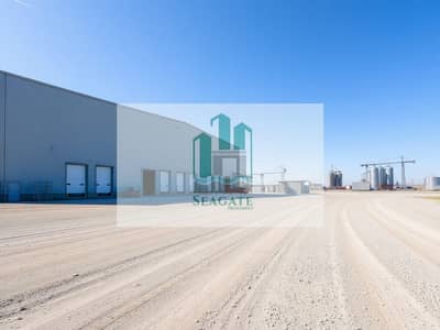 Industrial Land for Sale in Al Qasimia, Sharjah - An_empty_industrial_land_plot_with_a_large_warehouse_structure_prominently_featured. _The_warehouse_has_a_metal_facade_with_large_loading_docks_and_a_few_vehicles_parked_outside. _Nearby_there_is_a_labour_camp_with_sim. jpeg Industrial Land for Sale in Al Qasimia, Sharjah - An_empty_industrial_land_plot_with_a_large_warehouse_structure_prominently_featured. _The_warehouse_has_a_metal_facade_with_large_loading_docks_and_a_few_vehicles_parked_outside. _Nearby_there_is_a_labour_camp_with_sim. jpeg