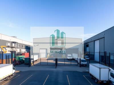 Warehouse for Sale in Al Sajaa, Sharjah - A_gated_warehouse_located_in_a_bustling_industrial_area_featuring_a_sturdy_modern_design. _The_warehouse_has_large_loading_bays_and_a_prominent_entrance_gate. _Surrounding_the_warehouse_are_other_industrial_buildings_m. jpeg Warehouse for Sale in Al Sajaa, Sharjah - A_gated_warehouse_located_in_a_bustling_industrial_area_featuring_a_sturdy_modern_design. _The_warehouse_has_large_loading_bays_and_a_prominent_entrance_gate. _Surrounding_the_warehouse_are_other_industrial_buildings_m. jpeg