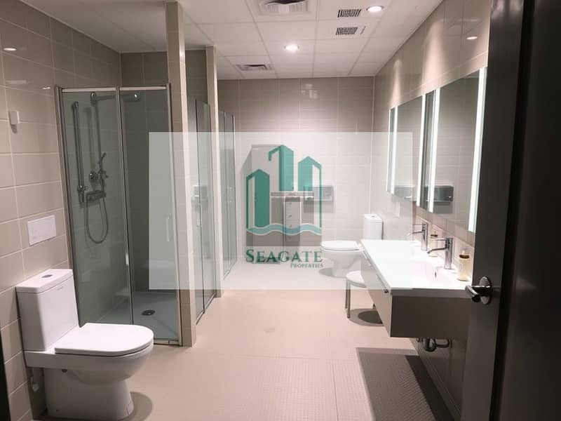 4 An_interior_view_of_a_spacious_bathroom_designed_for_four_person_labor_accommodation. _The_bathroom_features_multiple_shower_stalls_modern_sinks_with_ample_counter_space_and_separate_stalls_for_toilets. _The_decor_is_p. jpeg