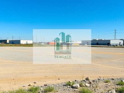 Industrial Land para en Venta en Al Sajaa Industrial, Sharjah - An_empty_industrial_plot_of_land_characterized_by_a_spacious_area_covered_with_dirt_and_gravel_prepared_for_future_construction. _In_the_background_several_nearby_industrial_buildings_and_warehouses_are_visible_under - Copy. jpeg