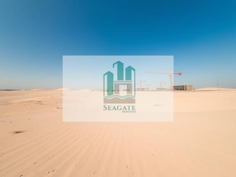4 A_wide_angle_view_of_an_industrial_plot_in_the_UAE_showcasing_a_vast_expanse_of_smooth_sand_with_faint_markings_indicating_future_development_areas. _The_terrain_is_dry_and_light_beige_dotted_with_sparse_grasses_and_s. jpeg