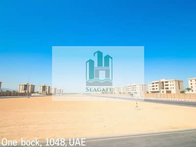 Mixed Use Land te Koop in Al Rawda, Ajman - A_large_empty_residential_plot_in_the_UAE_situated_one_block_from_a_road. _The_scene_features_an_expansive_flat_sandy_terrain_without_trees_or_signs_creating_an_open_unobstructed_view. _The_sky_is_bright_blue_typic (1). jpeg