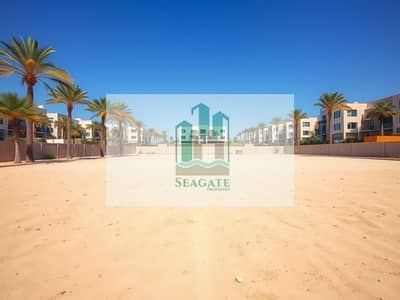 Mixed Use Land for Sale in Al Rawda, Ajman - A_vast_open_plot_of_land_in_a_suburban_area_showcasing_an_enormous_expanse_of_sandy_ground_bordered_by_a_low_wall. _The_scene_is_bright_and_sunny_with_palm_trees_scattered_throughout_the_landscape. _In_the_background_m. jpeg Mixed Use Land for Sale in Al Rawda, Ajman - A_vast_open_plot_of_land_in_a_suburban_area_showcasing_an_enormous_expanse_of_sandy_ground_bordered_by_a_low_wall. _The_scene_is_bright_and_sunny_with_palm_trees_scattered_throughout_the_landscape. _In_the_background_m. jpeg