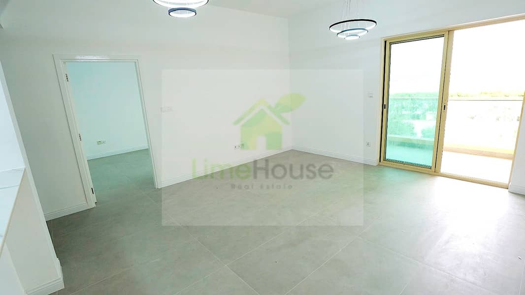 3 06-al-arta-4-greens-dubai-spacious-living-room-balcony-access-1br-apartment-rent. jpg