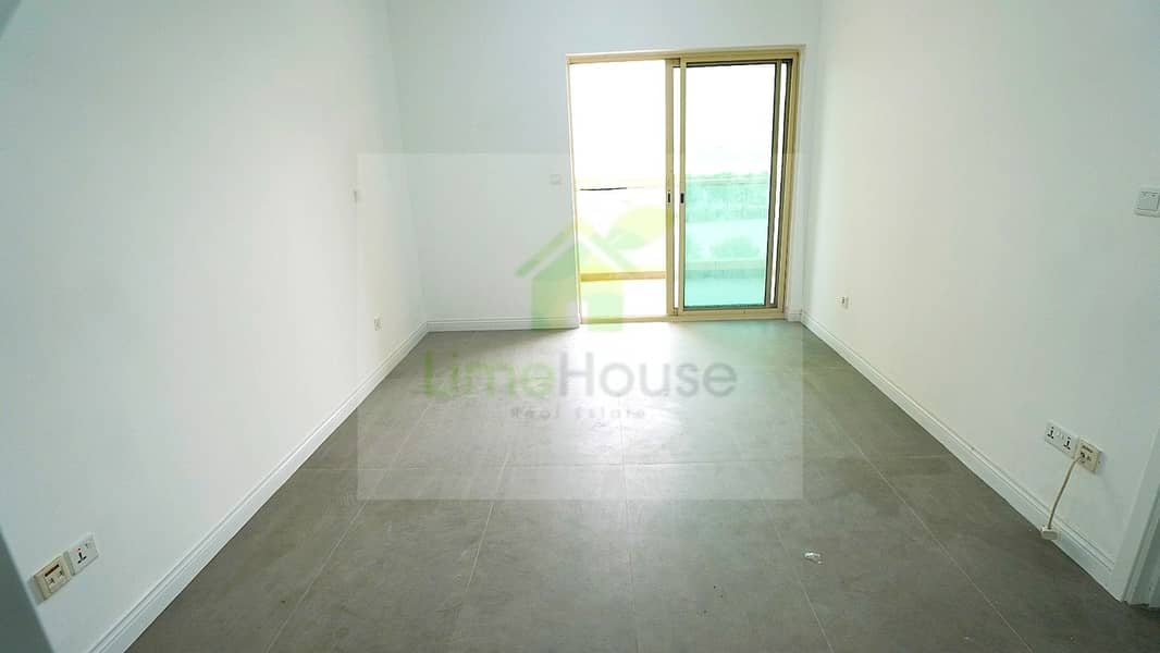5 08-al-arta-4-greens-dubai-living-room-grey-tiles-balcony-door-1br-apartment-rent. jpg