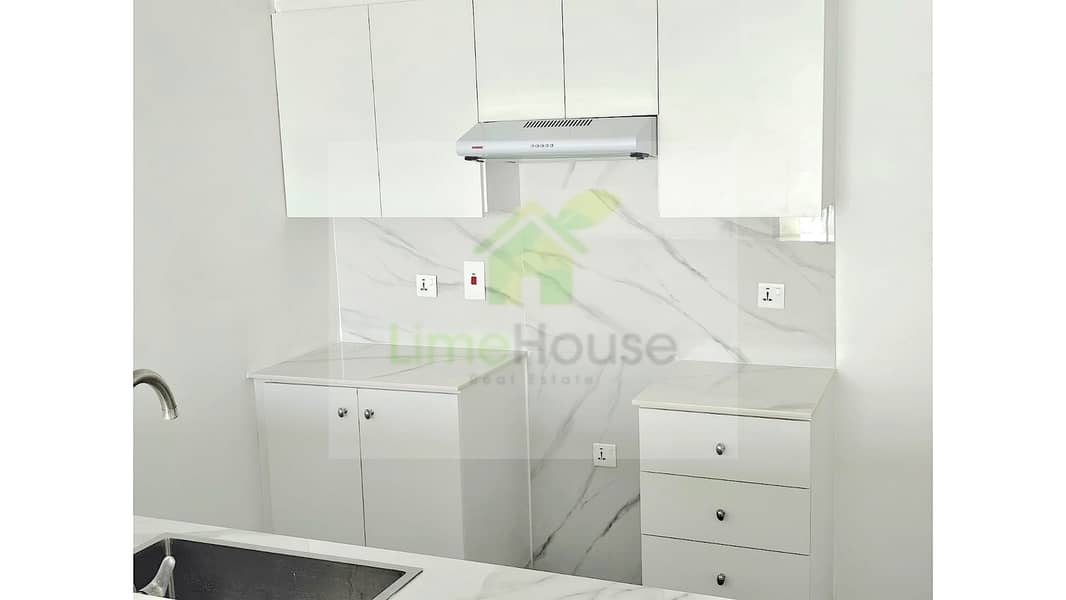 8 11-al-arta-4-greens-dubai-kitchen-white-cabinets-marble-backsplash-1br-apartment-rent. jpg