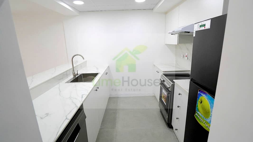 9 12-al-arta-4-greens-dubai-kitchen-renovated-black-fridge-marble-countertop-1br-apartment-rent. jpg