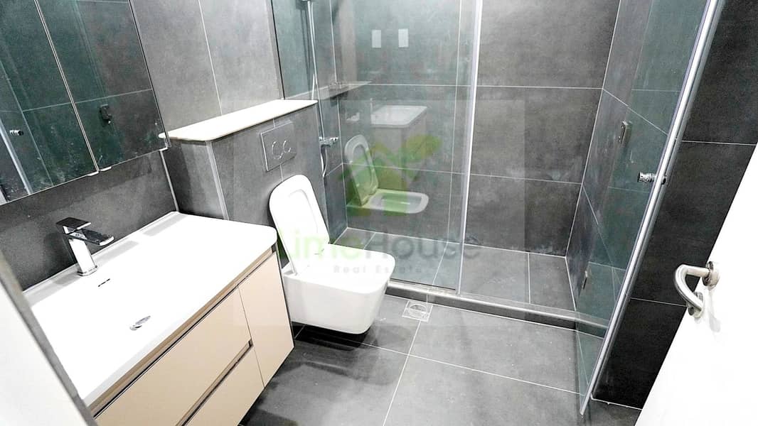 15 19-al-arta-4-greens-dubai-bathroom-dark-tile-glass-shower-1br-apartment-rent. jpg