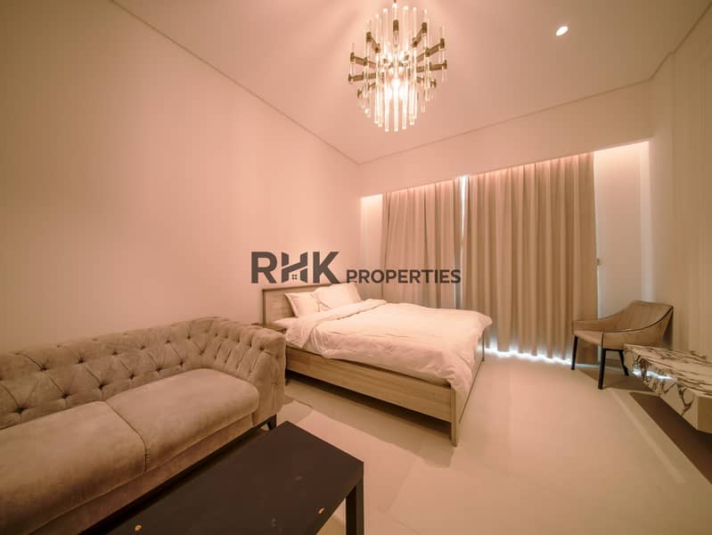 2 Luxury villa bedroom in Dubai with Chesterfield sofa, king bed, crystal chandelier, and warm neutral interior design