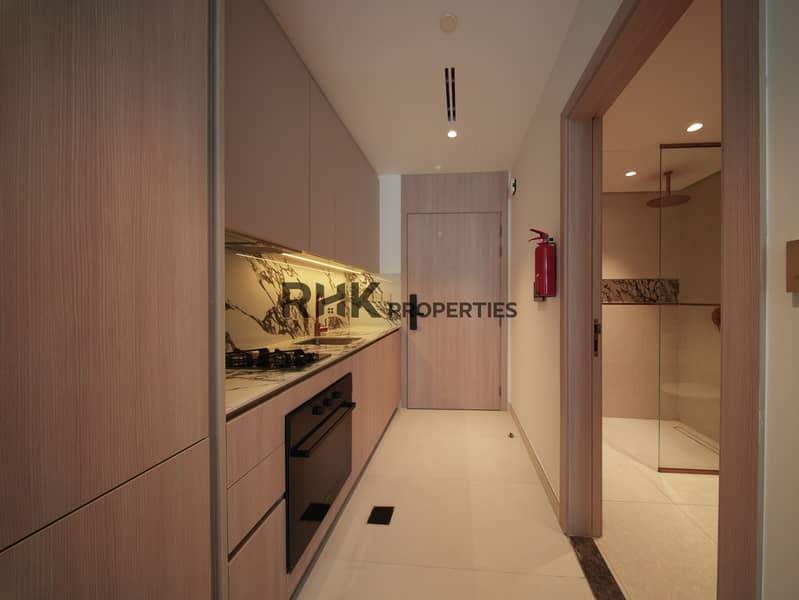 8 Stylish studio apartment entrance hallway with fitted kitchen, built-in oven, and premium finishes