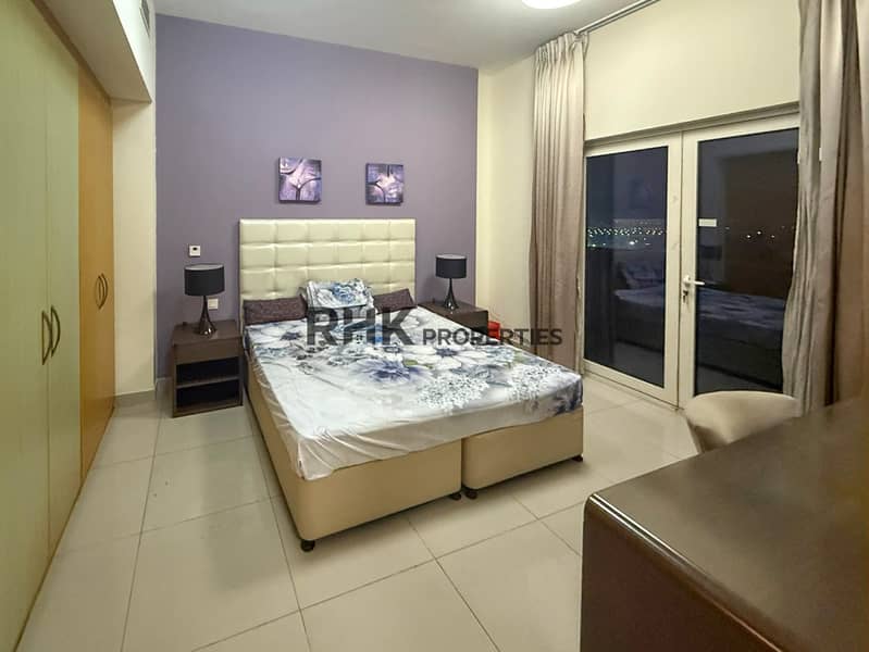 5 Master bedroom balcony access purple accent wall furnished Suburbia B Jebel Ali