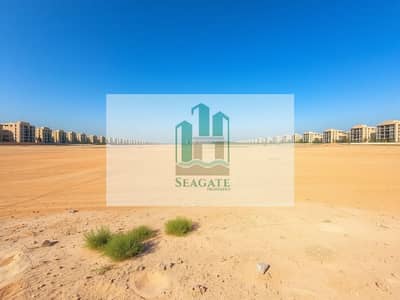 Mixed Use Land in vendita a Al Mowaihat, Ajman - A_vast_and_expansive_empty_land_in_a_semi_urban_setting_showcasing_a_wide_stretch_of_sandy_terrain. _The_foreground_features_small_green_patches_of_grass_and_scattered_desert_plants_while_the_background_displays_a_dis. jpeg