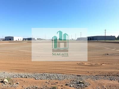 Industrial Land in vendita a Al Sajaa, Sharjah - An_empty_industrial_plot_of_land_characterized_by_a_spacious_area_covered_with_dirt_and_gravel_prepared_for_future_construction. _The_surrounding_landscape_shows_several_nearby_industrial_buildings_and_warehouses_with. jpeg