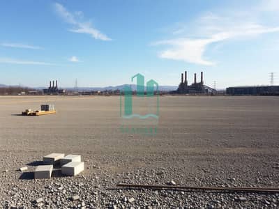 Industrial Land in vendita a Al Sajaa, Sharjah - An_empty_industrial_plot_showcasing_a_wide_expanse_of_land_prepared_for_development. _The_foreground_features_a_barren_gravelly_area_with_some_scattered_construction_materials_like_concrete_blocks_and_metal_rods. _Sur - Copy. jpeg