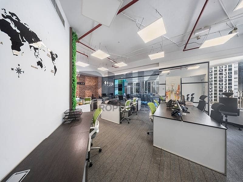 7 Open-plan office workstations with world map wall and tower views in JLT Dubai
