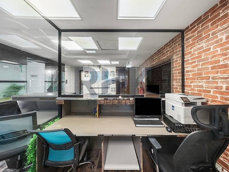 10 Fitted office workstation with exposed brick wall and glass partitions Dubai