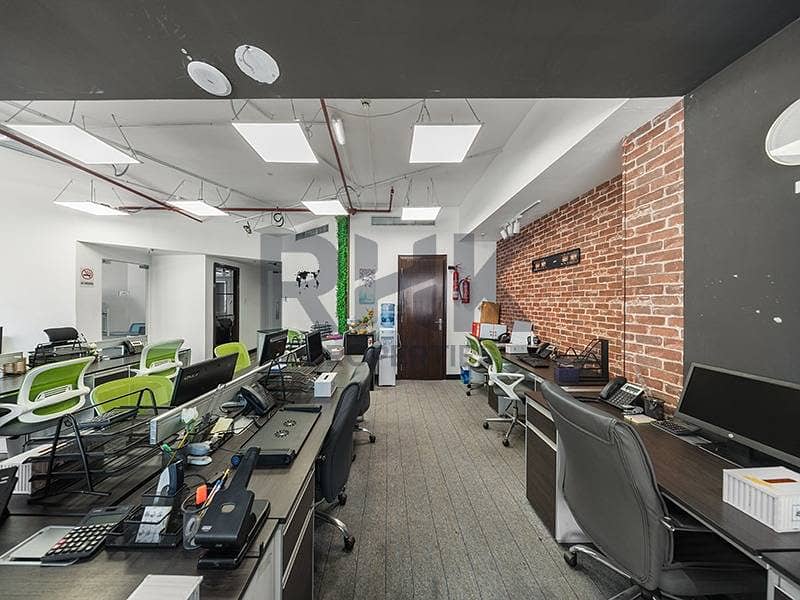 24 Open-plan office with rows of workstations and exposed brick wall in Dubai